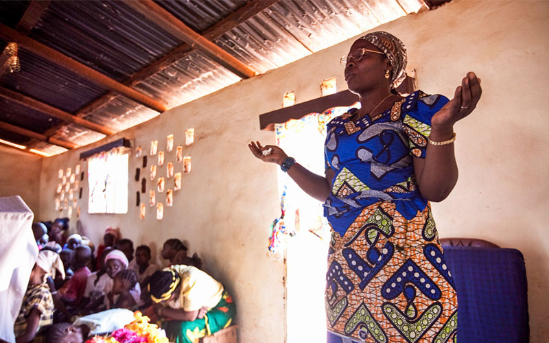 Central African Republic woman praying with hands raised